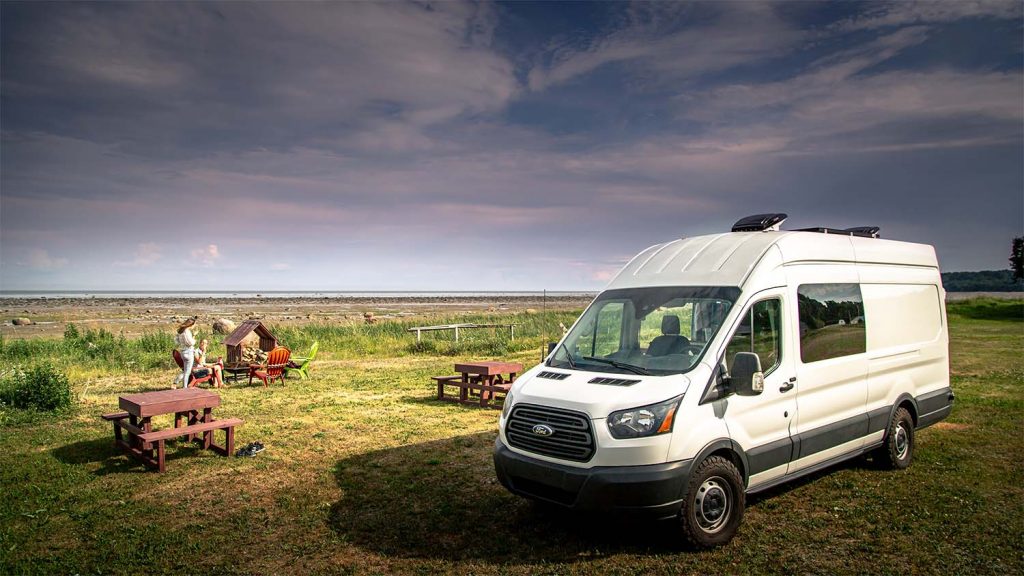 the care home minibus parked on the grass with a family exploring outside