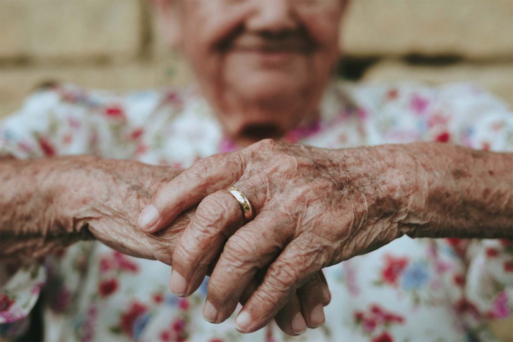 resident sat smiling with her hands held in front of her