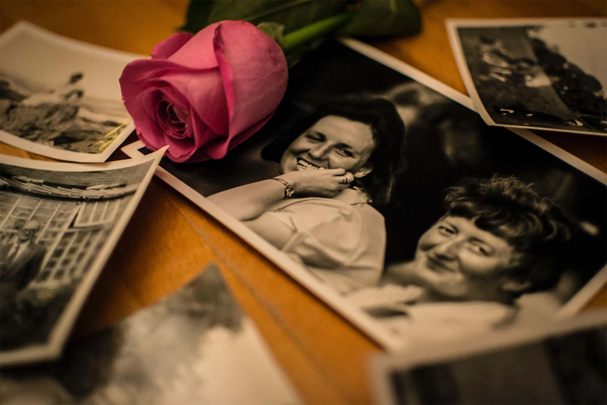 black and white photos of residents' loved ones with a rose laid on top