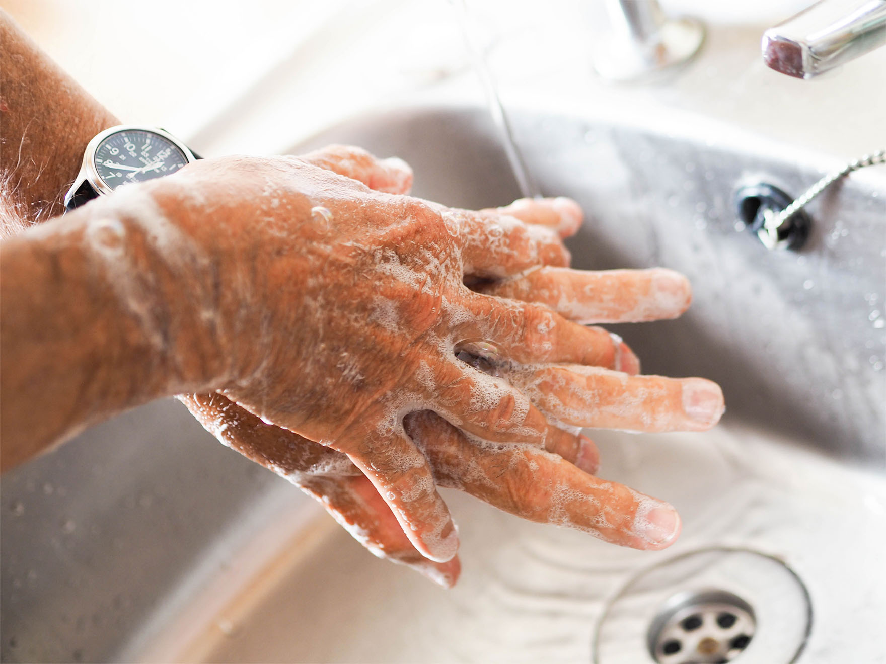 somebody washing their hands in a sink
