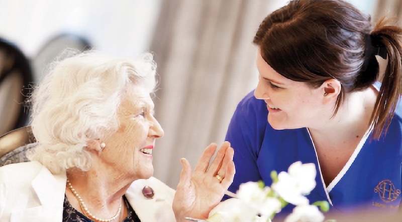 resident and carer smiling looking at each other