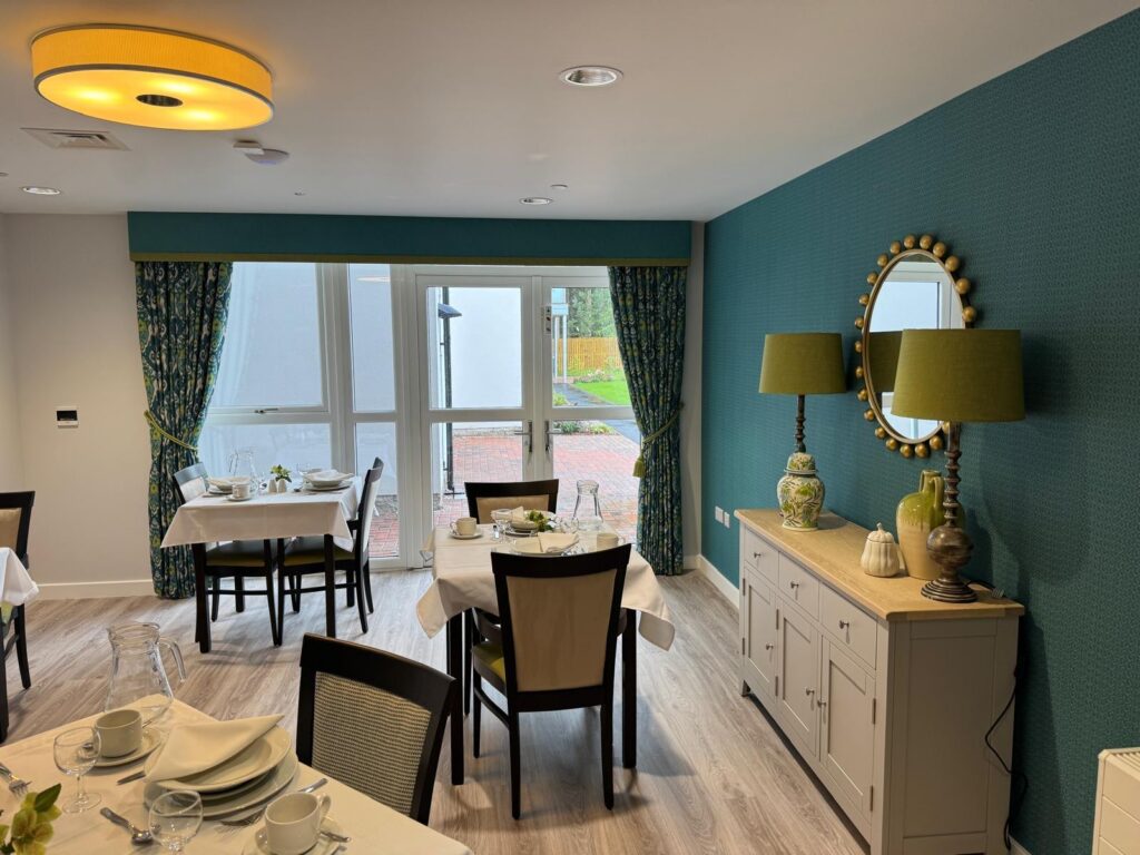 a communal dining area with dining tables and matching wooden chairs