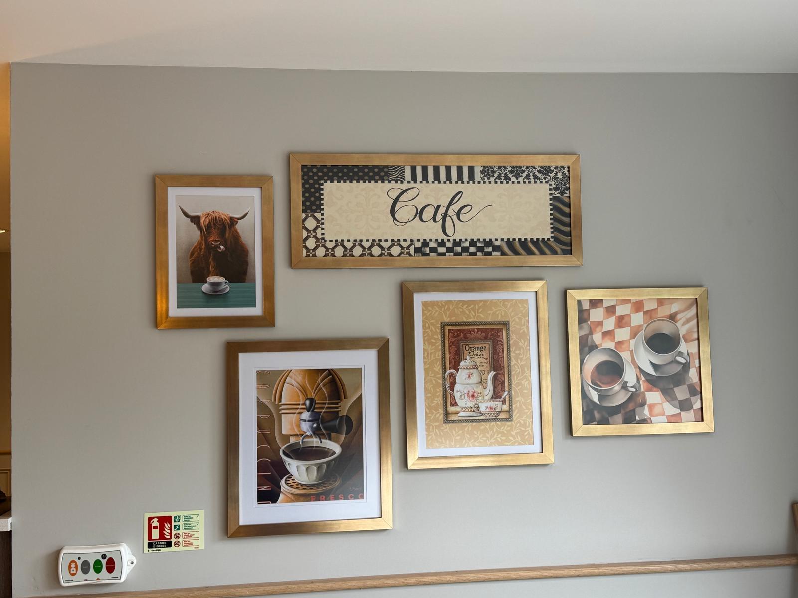 five pictures in golden frames hanging on a grey wall