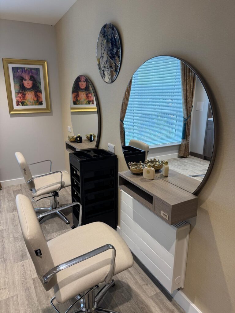 two cream, leather chairs on wheel in a salon facing circle mirrors