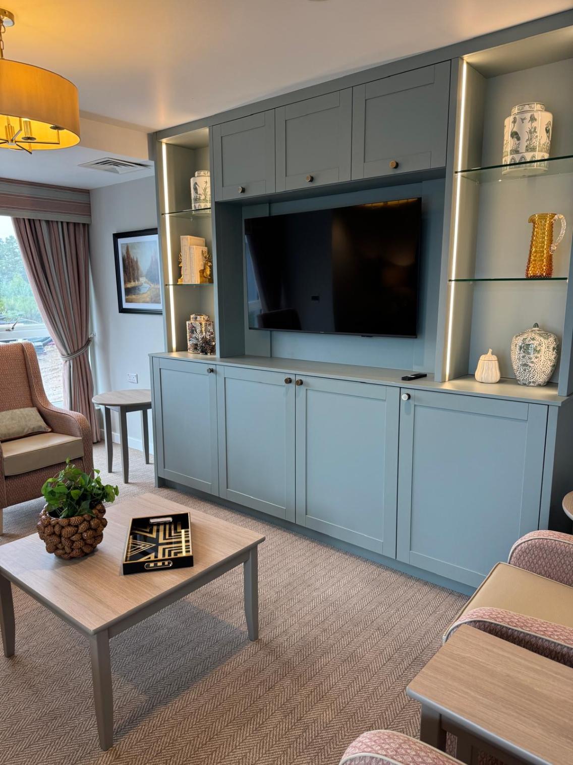 a tv in a grey cabinet with decorative objects around it